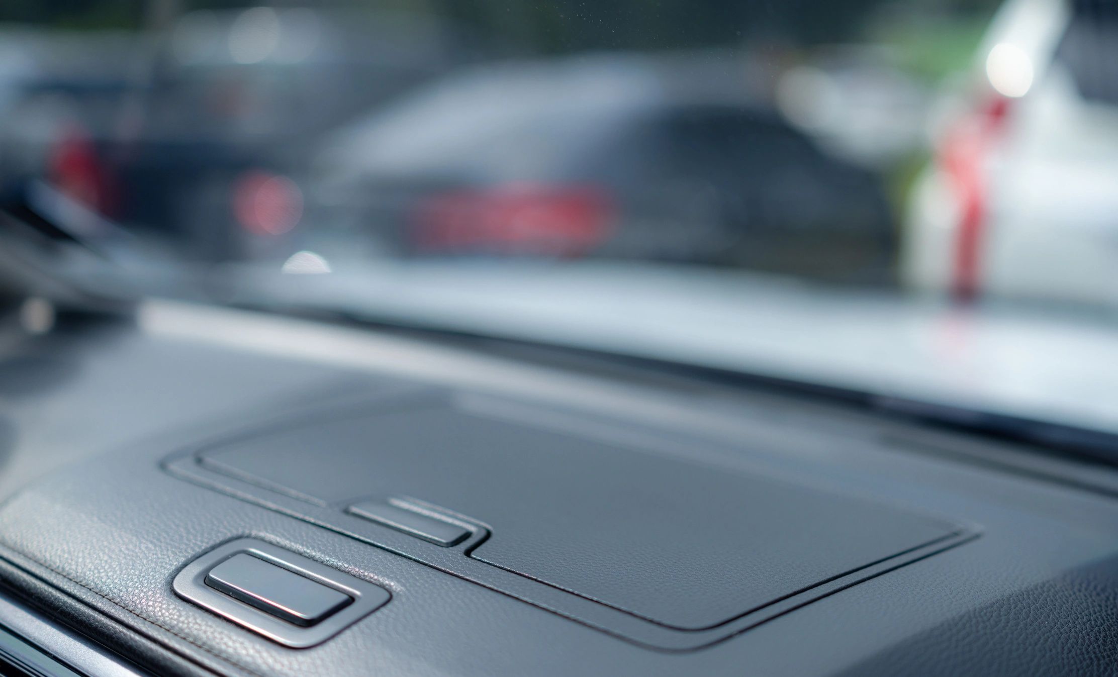 Close-up view from inside a car showing the dashboard and windshield